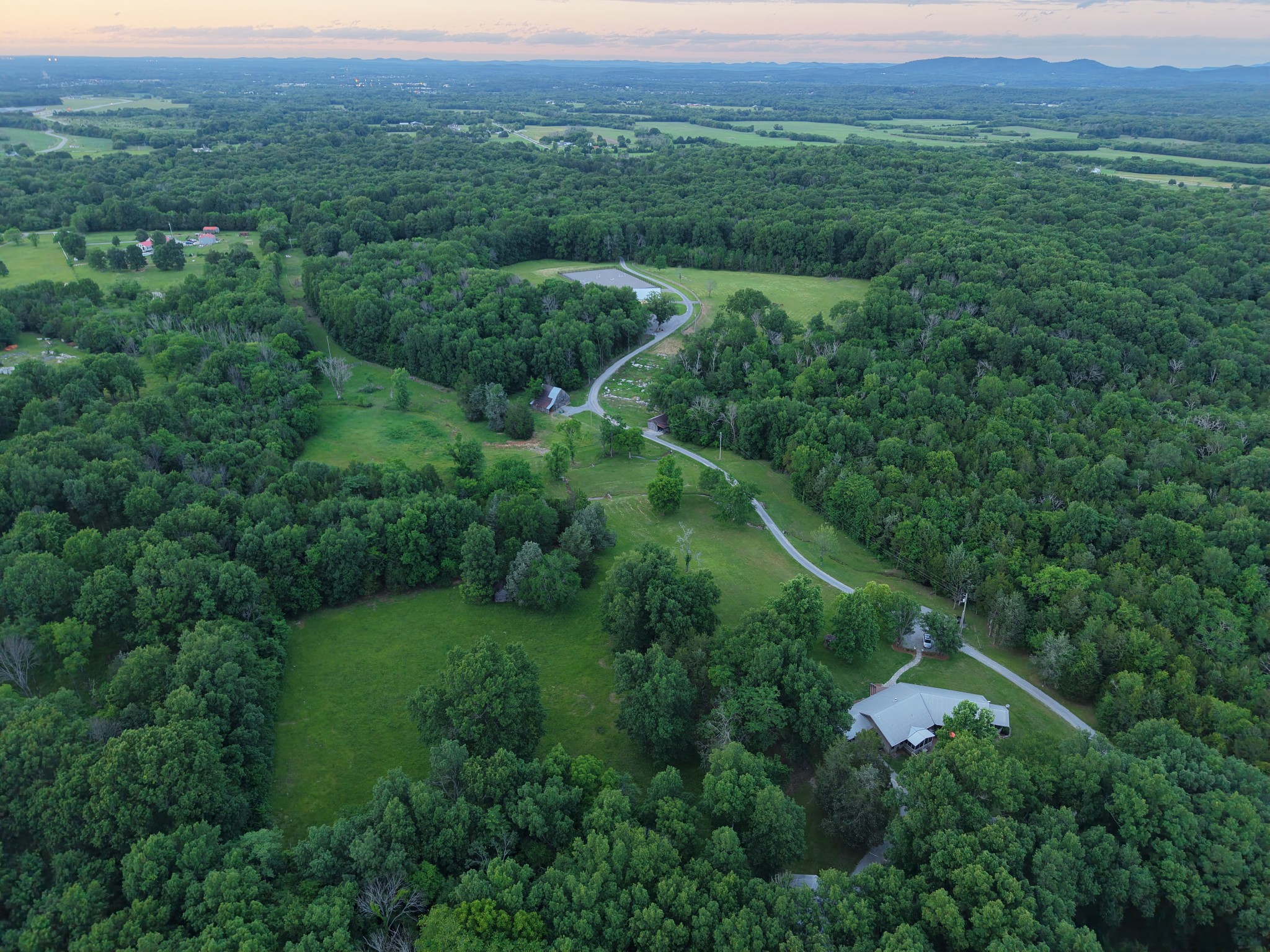 an aerial view of residential houses with outdoor space and trees
