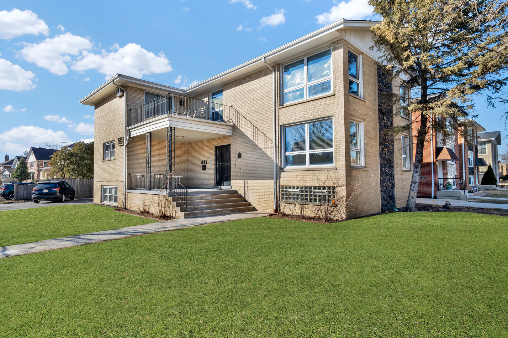 a view of a house with a big yard and large trees