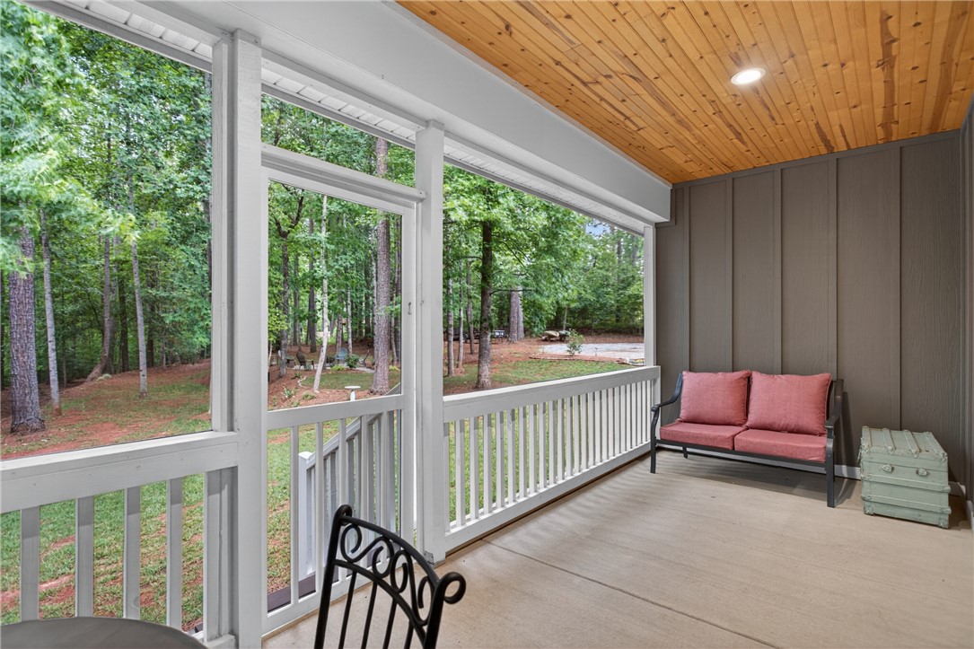 2024 Retreat Pointe Road West Union, SC 29696 - Photo 26 of 43 A secluded screened in back patio with wooden ceilings offers serene views of mature woodlands, perfect for quiet contemplation.