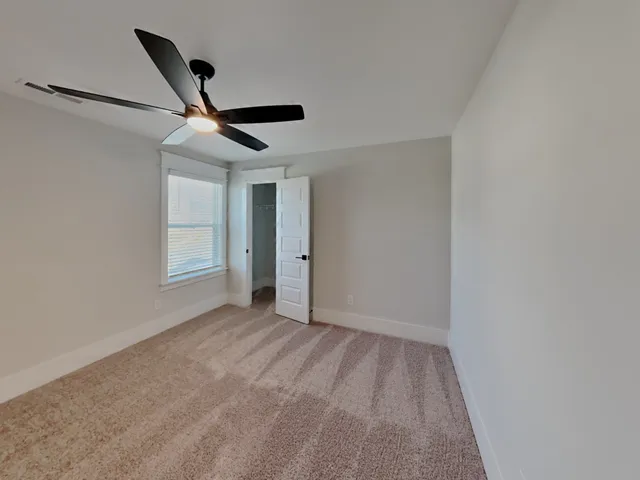 a view of empty room with ceiling fan