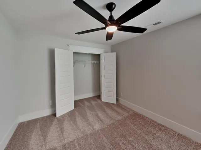 an empty room with a ceiling fan and a fan