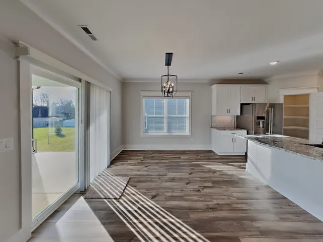 a view of a kitchen with kitchen island a sink stainless steel appliances and cabinets