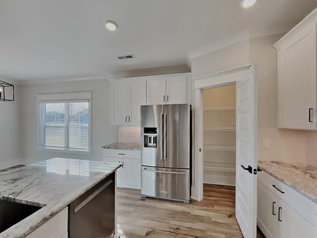 a kitchen with granite countertop a sink stove and refrigerator