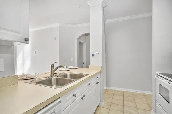 an empty room with chandelier fan and windows