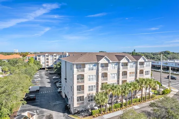 a view of a white building among the street and trees