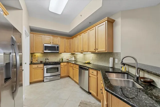 a kitchen with stainless steel appliances granite countertop a sink stove and refrigerator