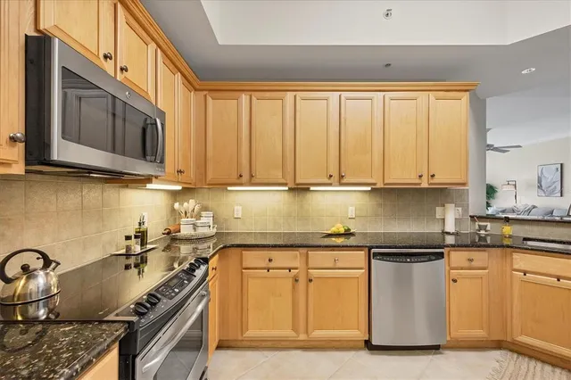 a kitchen with stainless steel appliances granite countertop a stove a sink and a microwave