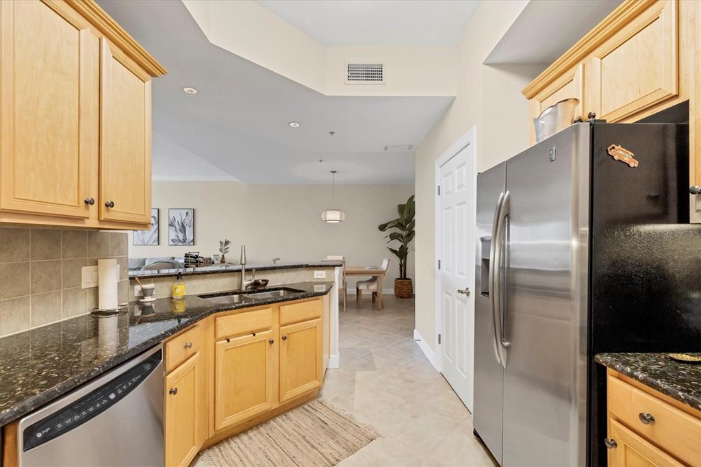 8541 Amberjack Circle, Unit 203 Englewood, FL 34224 - Photo 15 of 52 a kitchen with stainless steel appliances granite countertop a refrigerator a sink and white cabinets