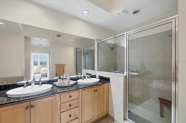 a bathroom with a granite countertop sink mirror and shower