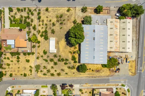 an aerial view of a residential apartment building with a yard and parking spaces