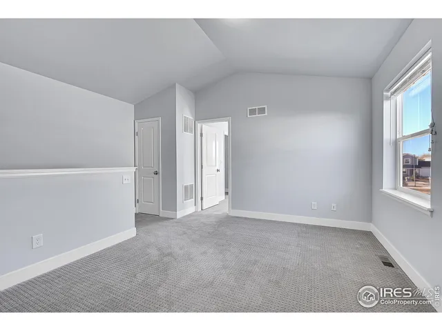 a view of an empty room with window and a ceiling fan