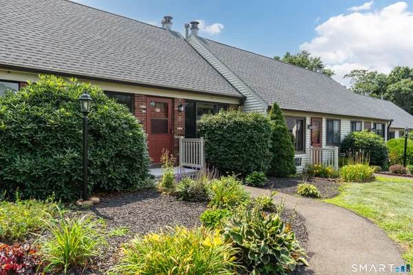 a front view of a house with a yard and outdoor seating