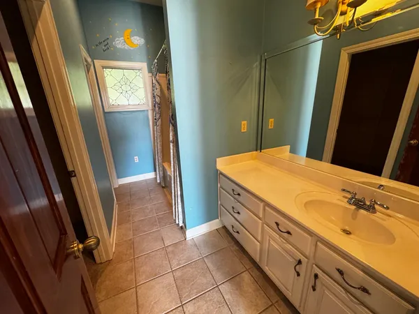 a bathroom with a granite countertop sink a toilet and a mirror