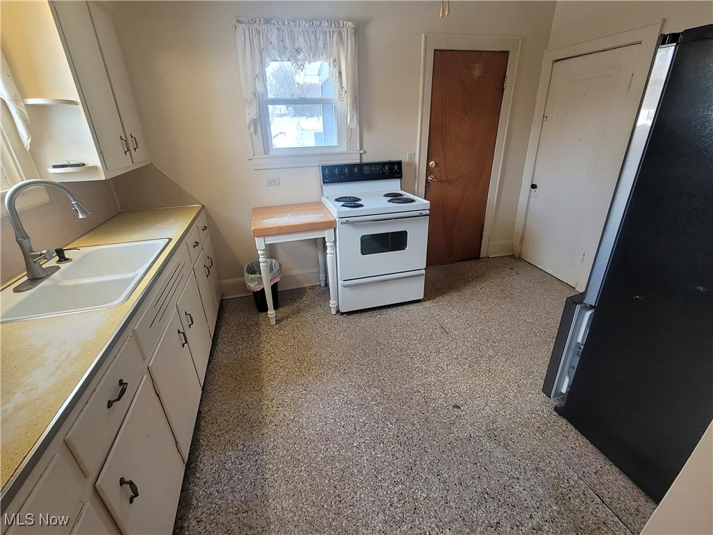 4145 Manchester Road Akron, OH 44319 - Photo 16 of 28 Kitchen with freestanding refrigerator, white electric stove, white cabinets, and light countertops