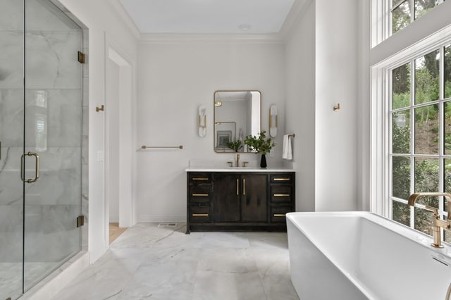 a bathroom with a tub sink and mirror