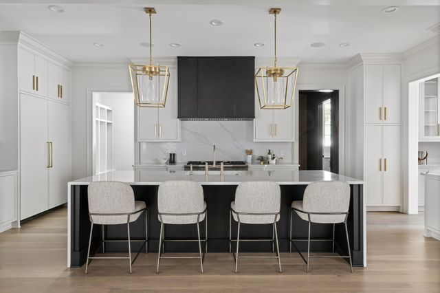 a kitchen with a dining table chairs wooden floor and appliances