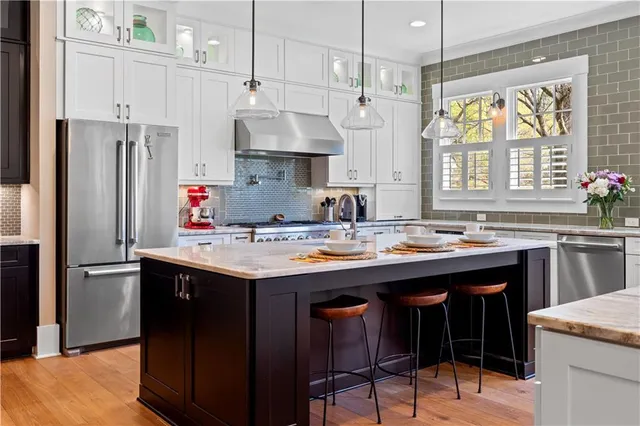 a kitchen with stainless steel appliances granite countertop a stove a refrigerator and a sink