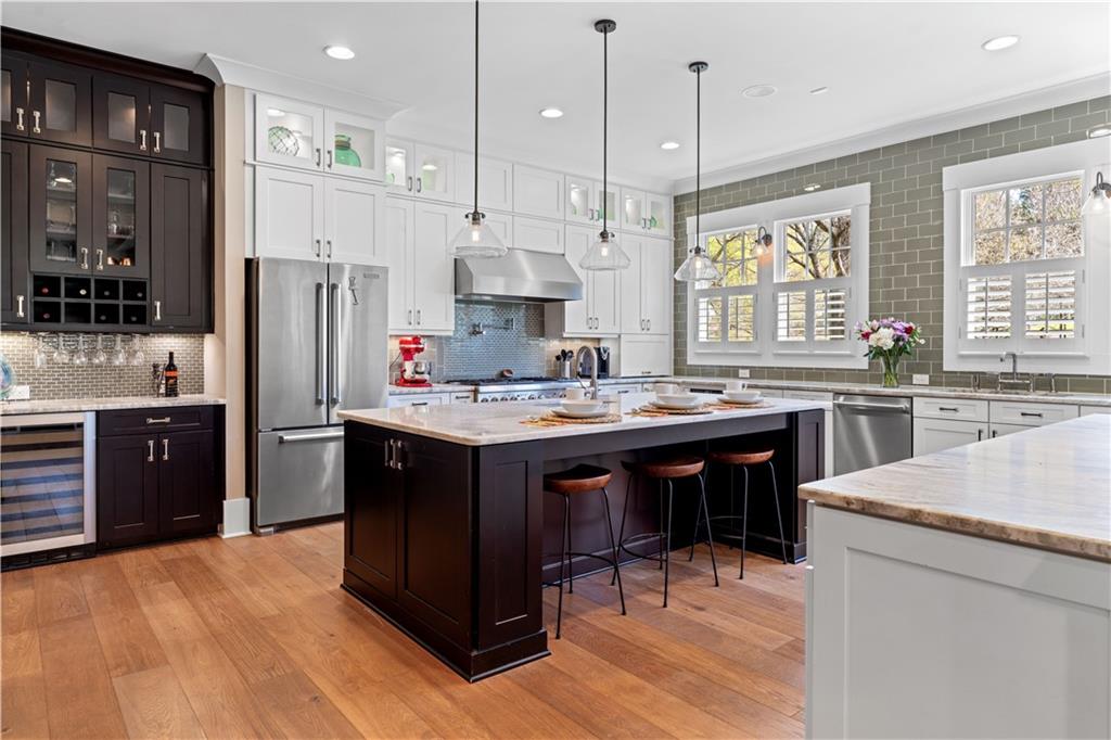 958 Austin Avenue Northeast Atlanta, GA 30307 - Photo 23 of 68 a kitchen with stainless steel appliances kitchen island granite countertop a sink refrigerator and cabinets