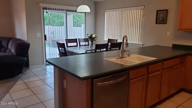 a dining table with chairs and next to a window