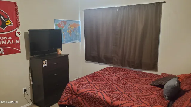 a bedroom with a bed and a flat tv screen