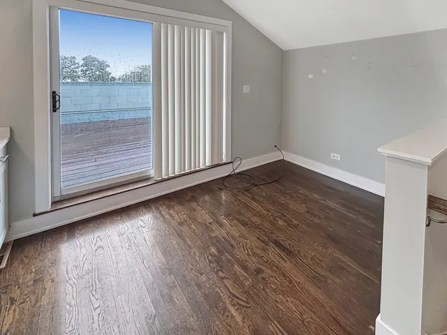 a view of a room has wooden floor and a window