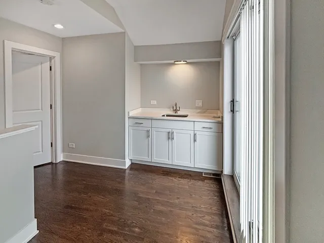 a view of a kitchen with white cabinets and wooden floor