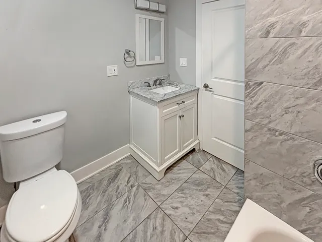 a bathroom with a toilet a sink and a mirror