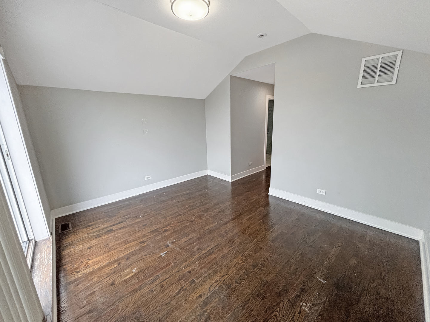 1634 West Cermak Road, Unit 3 Chicago, IL 60608 - Photo 7 of 19 an empty room with wooden floor and windows