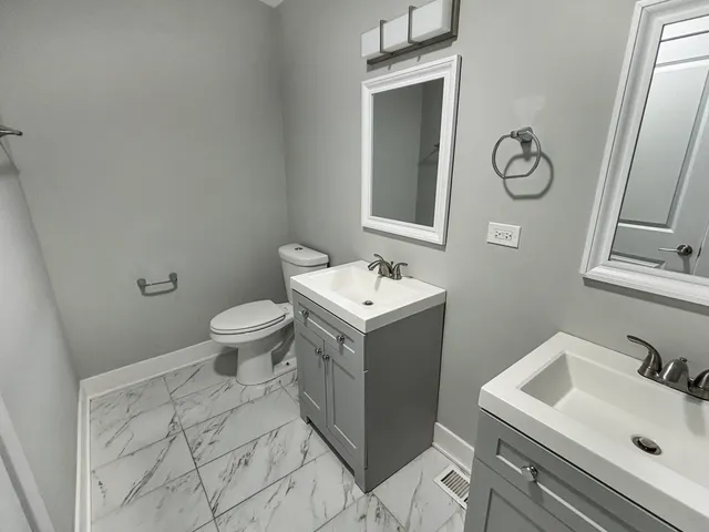 a bathroom with a sink toilet and mirror