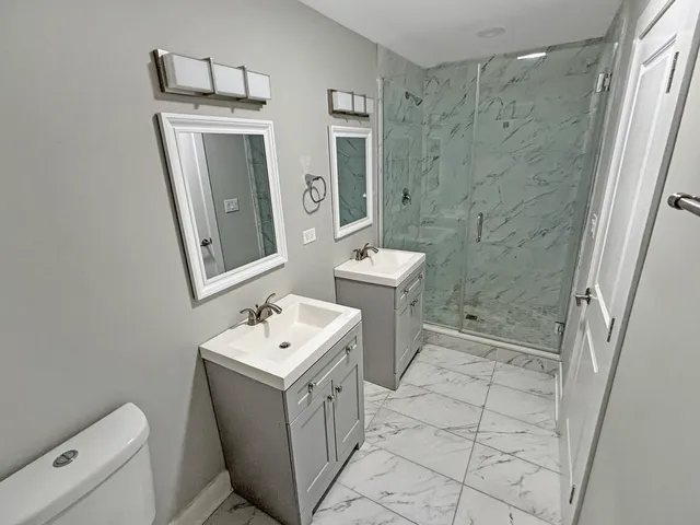 a bathroom with a sink a toilet and shower