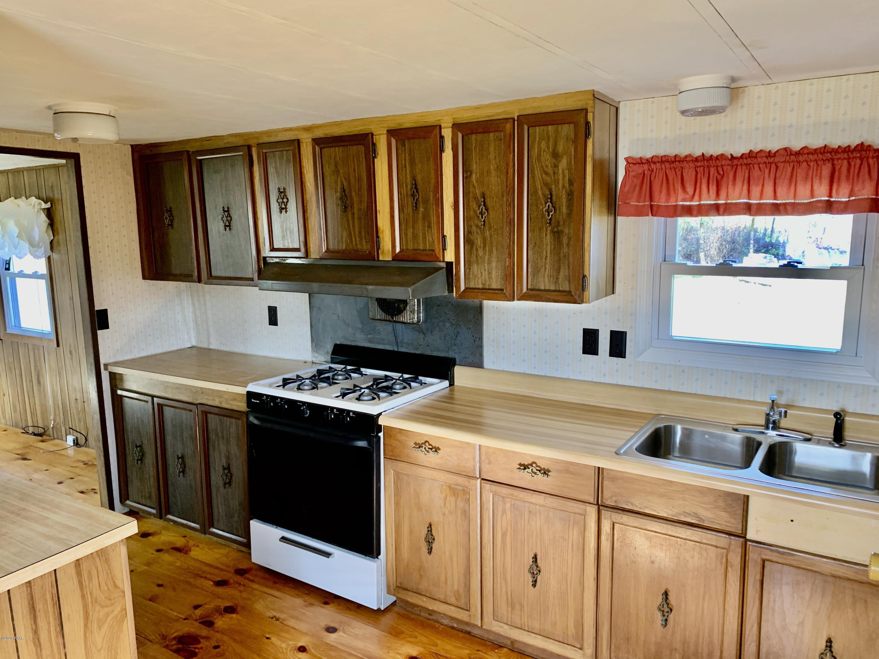 99 Slater Road Beach Lake, PA 18405 - Photo 12 of 35 a kitchen with stainless steel appliances granite countertop a stove a sink and a microwave