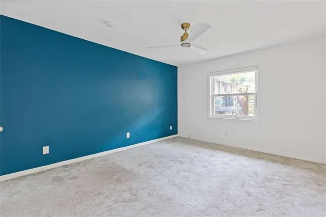 an empty room with windows and ceiling fan