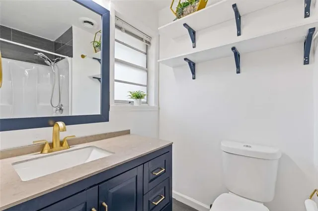 a bathroom with a sink toilet a mirror and shower