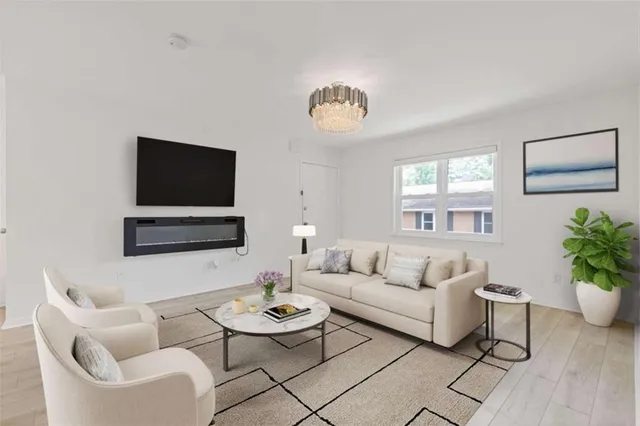 a living room with furniture a flat screen tv and a window