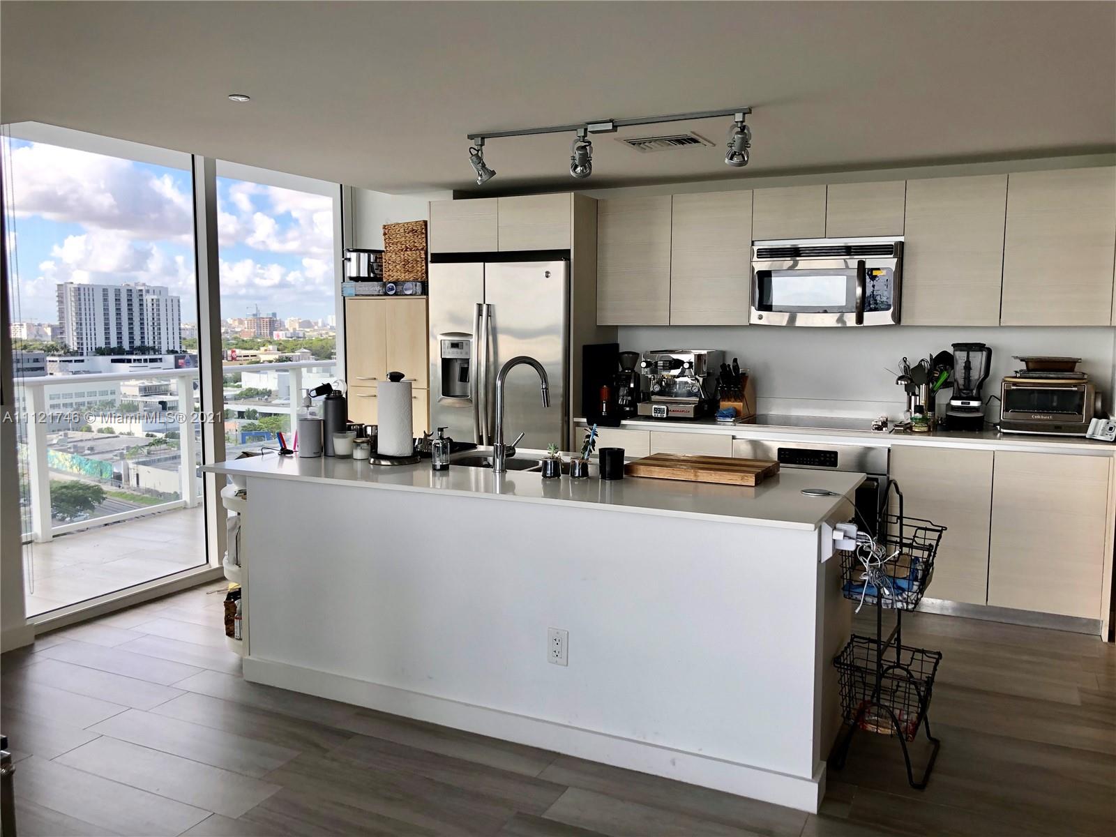 4250 Biscayne Boulevard, Unit 1601 Miami, FL 33137 - Photo 11 of 18 a kitchen with stainless steel appliances a refrigerator a sink a stove and white cabinets