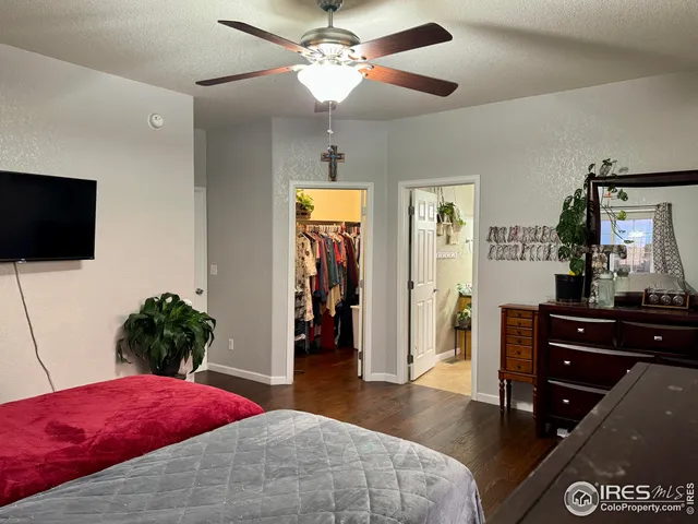 a bedroom with a bed and a flat tv screen on dresser