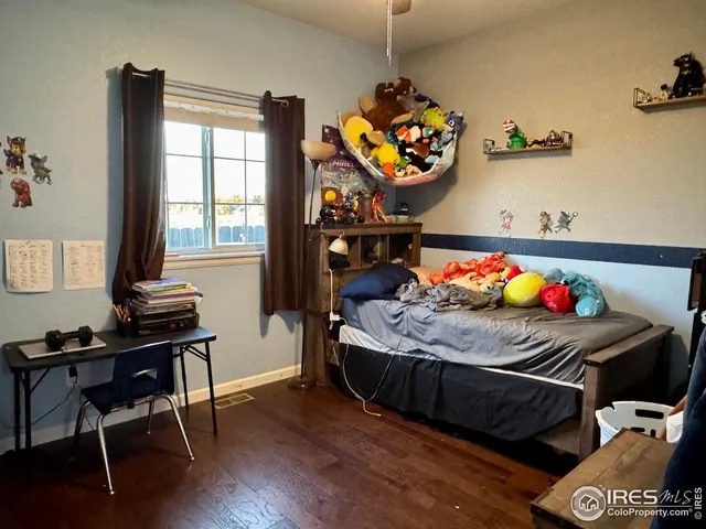 a bedroom with a bed and a wooden floor