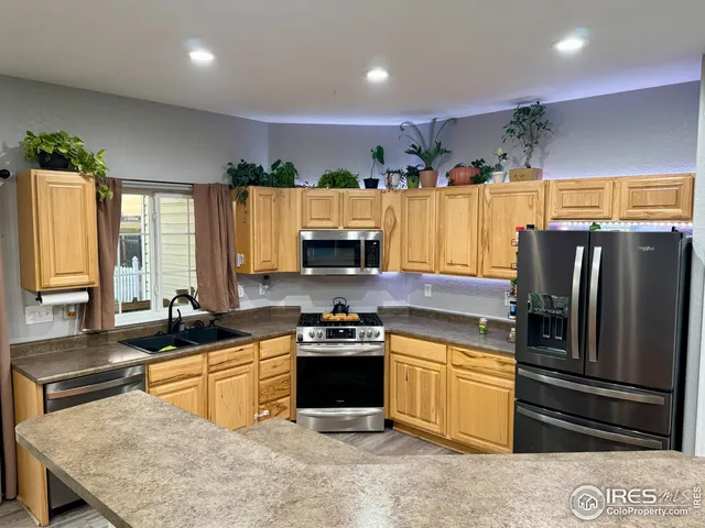 a kitchen with stainless steel appliances granite countertop a sink a stove and a refrigerator