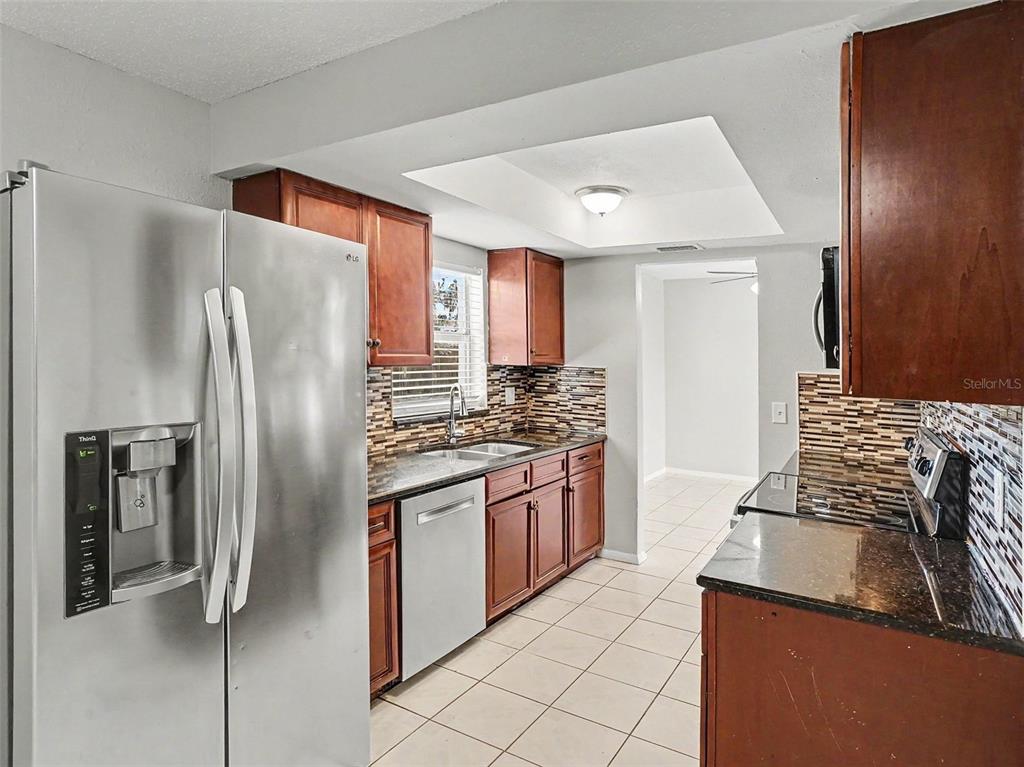 615 Thomas Jefferson Way Orlando, FL 32809 - Photo 5 of 17 a kitchen with stainless steel appliances granite countertop a refrigerator and a stove