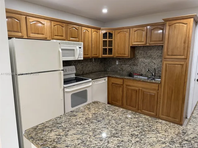 a kitchen with stainless steel appliances granite countertop a refrigerator sink and cabinets