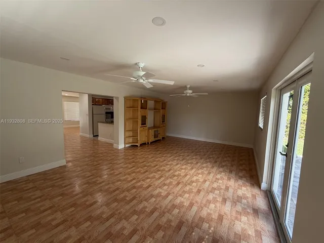 an empty room with wooden floor and a window