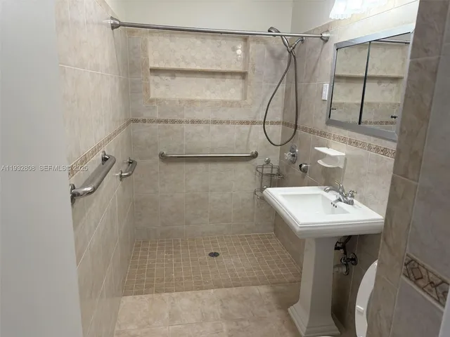 a bathroom with a shower sink and mirror