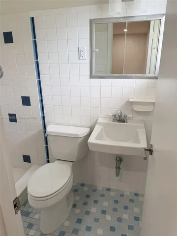 a bathroom with a sink toilet and mirror