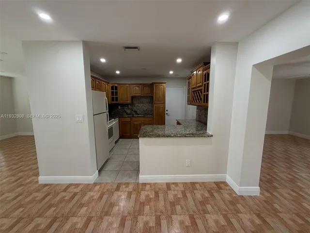 a view of a kitchen with a sink and a refrigerator