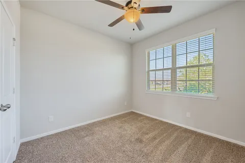 an empty room with a window and a fan