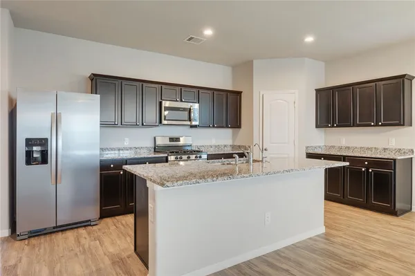 a kitchen with stainless steel appliances granite countertop a refrigerator stove microwave and sink