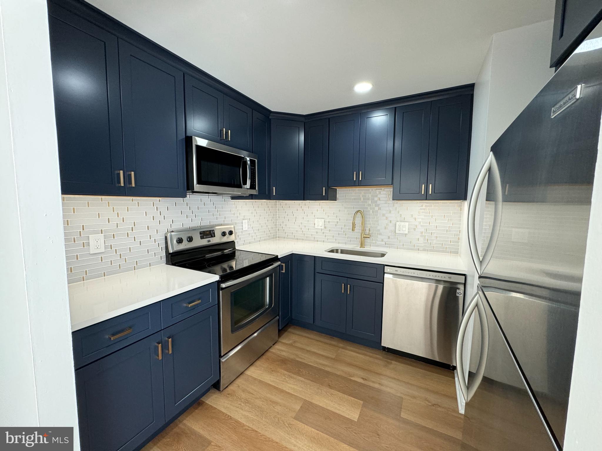 6135 Edsall Road, Unit N Alexandria, VA 22304 - Photo 4 of 9 a kitchen with stainless steel appliances granite countertop a sink stove microwave and refrigerator