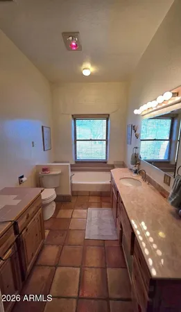a bathroom with a granite countertop sink a toilet and bathtub