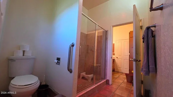 a bathroom with a toilet and a shower