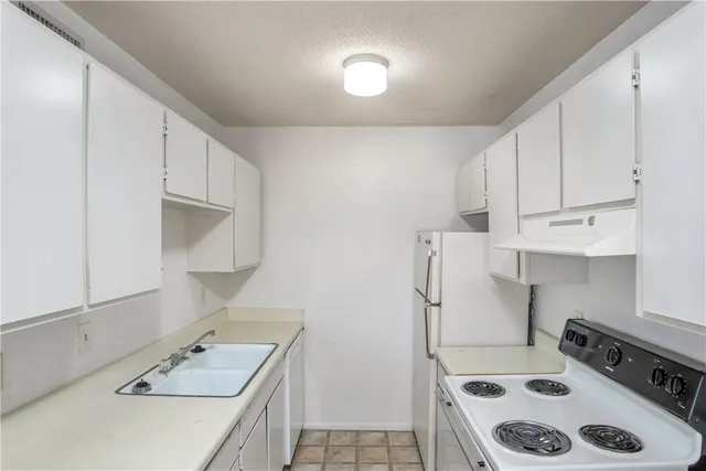a kitchen with a sink a stove and refrigerator